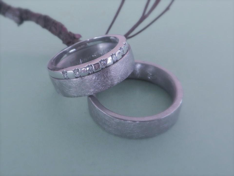 Zylindrische Trauringe aus eismattem Weißgold mit ansteckbarem Verlobungsring.