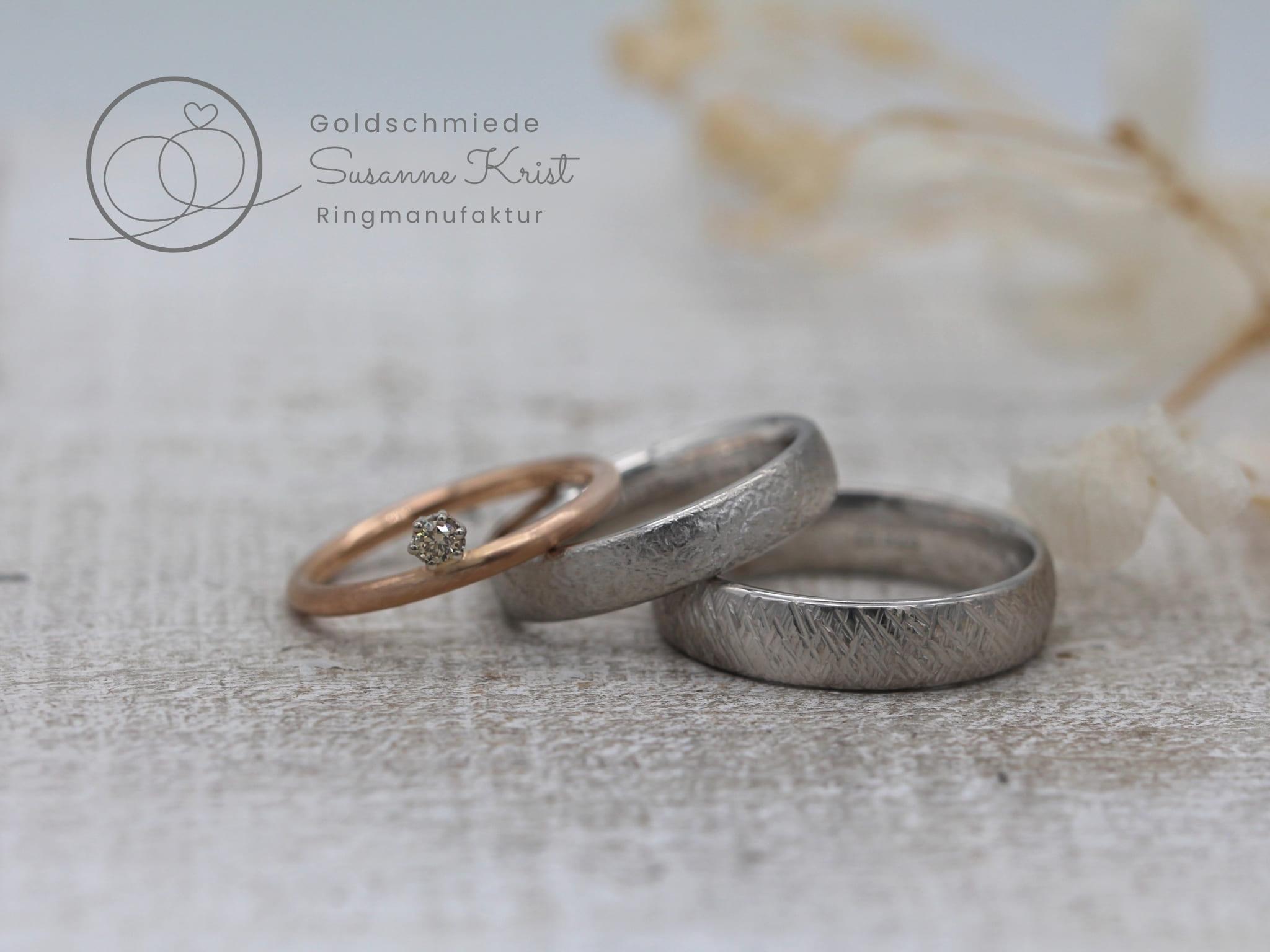 Rotgoldring als Vorsteckring und Platinringe mit Texturen.
