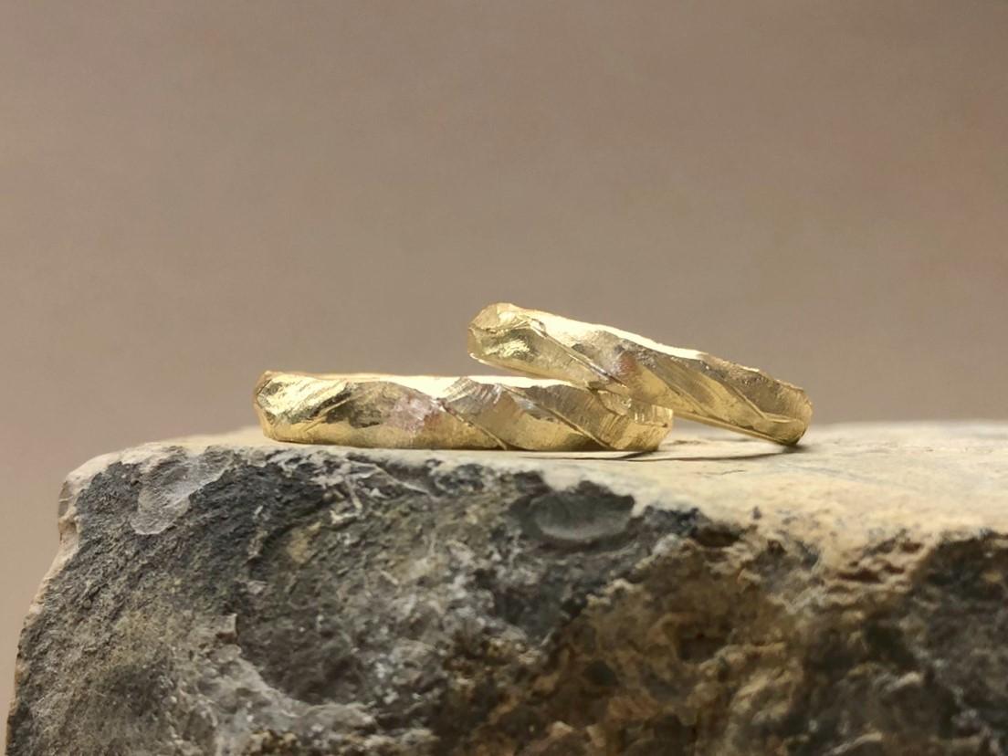 Wellige Eheringe mit starker Musterung in Gold namens Bucht